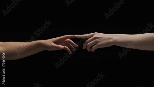 Portrait of models hands isolated on black background. Man and woman naked hands lending to each other and touch fingers.