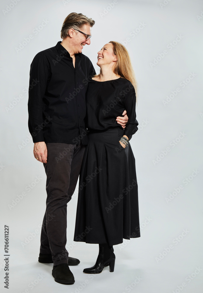Portrait of married couple arm in arm dressed elegantly in black. Studio shot Portrait of married couple arm in arm dressed elegantly in black. Studio shot