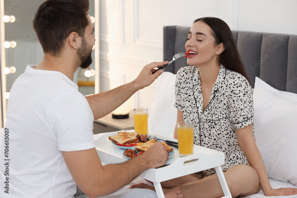 Happy couple having breakfast on bed at home Happy couple having breakfast on bed at home
