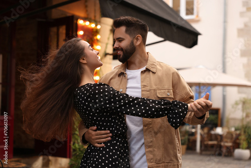 Lovely couple dancing together on city street