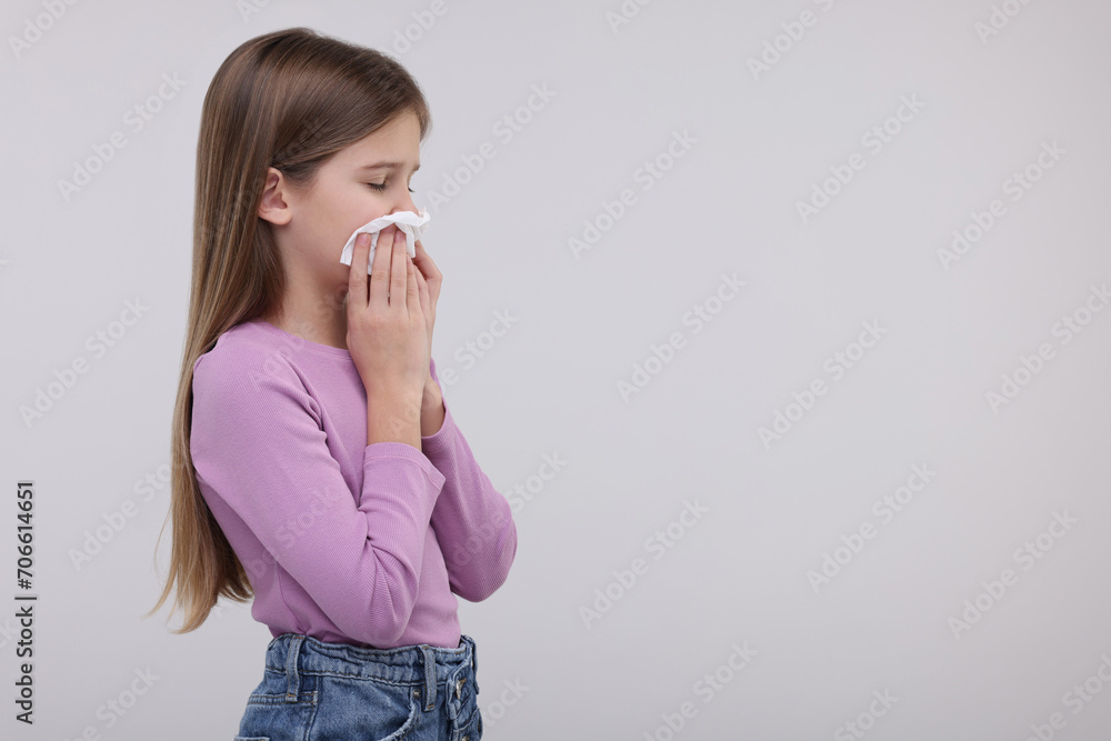 Sick girl with tissue coughing on light background, space for text Sick girl with tissue coughing on light background, space for text