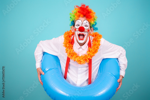 Funny clown and different situations. A happy guy is waiting for a vacation. Blue background. photo