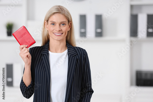 Immigration. Happy woman with passport indoors, space for text photo