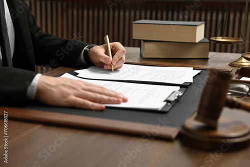Canvas Print Lawyer working with documents at wooden table indoors, closeup
