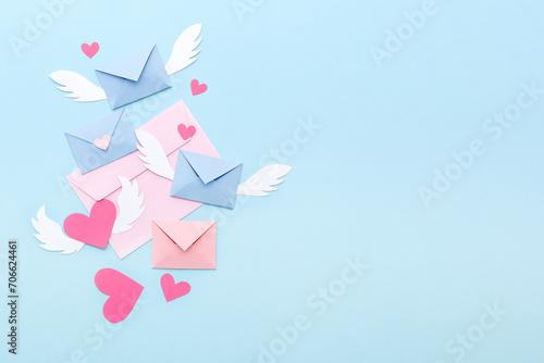 Love letters and pink paper hearts on a blue background. Valentine's Day. Top view. Space for text.