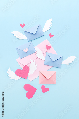 Love letters and pink paper hearts on a blue background. Valentine's Day. Top view.