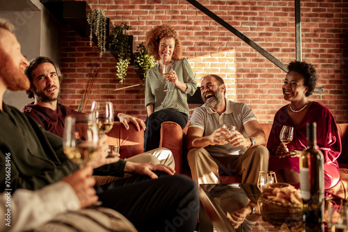 Group of Friends Enjoying Wine and Laughter in Cozy Living Room photo