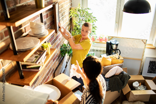 Lesbian couple unpacking boxes and setting up their new kitchen photo