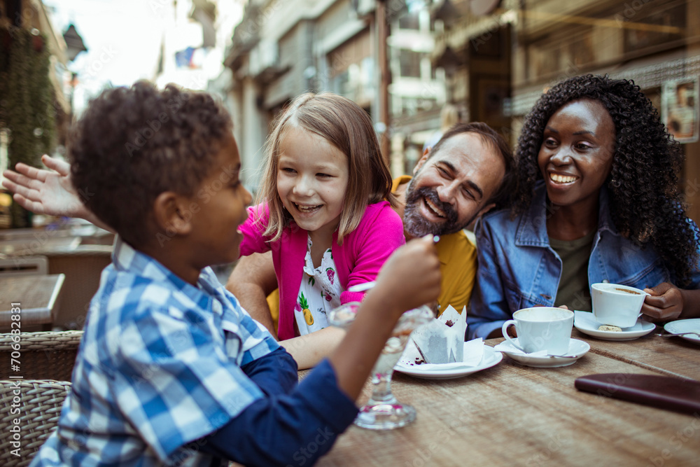 Multicultural family enjoying desserts at an outdoor cafe Multicultural family enjoying desserts at an outdoor cafe