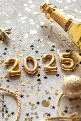 Golden 2025 new year numbers with confetti and champagne bottle