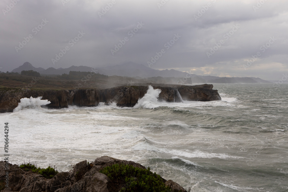 Bufones de Pria in Asturias coast on a cloudy day with rough seas and wave spray