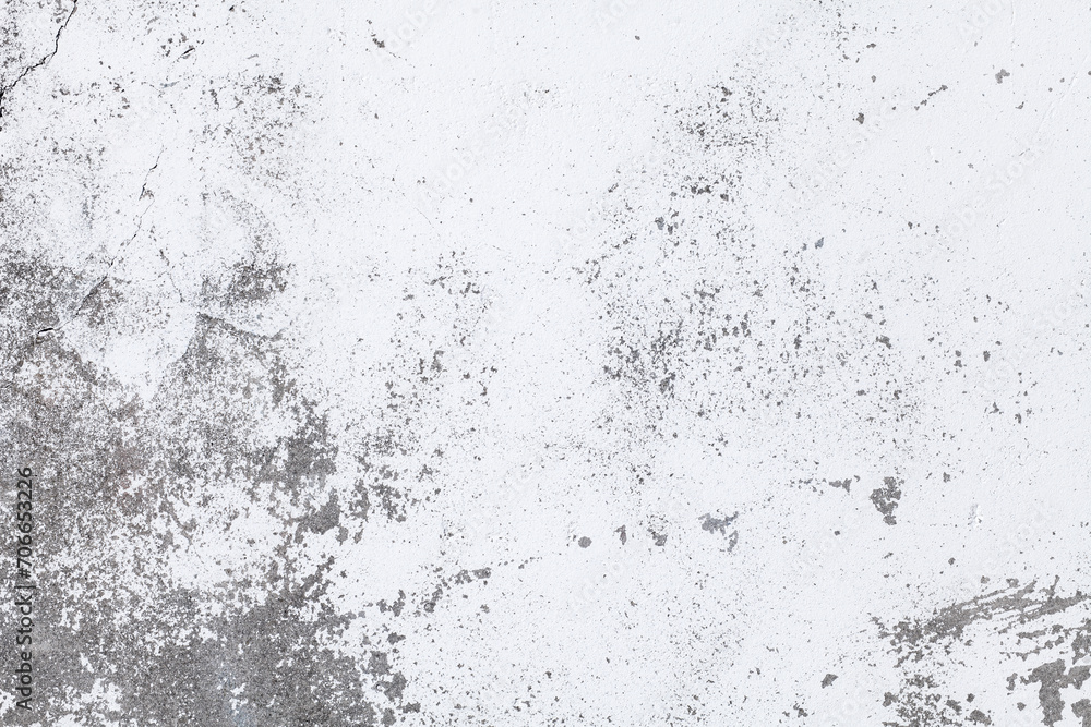 Concrete wall surface with white cracked paint. Old concrete wall background. Abstract grey wall texture with white cracked paint. Close up.