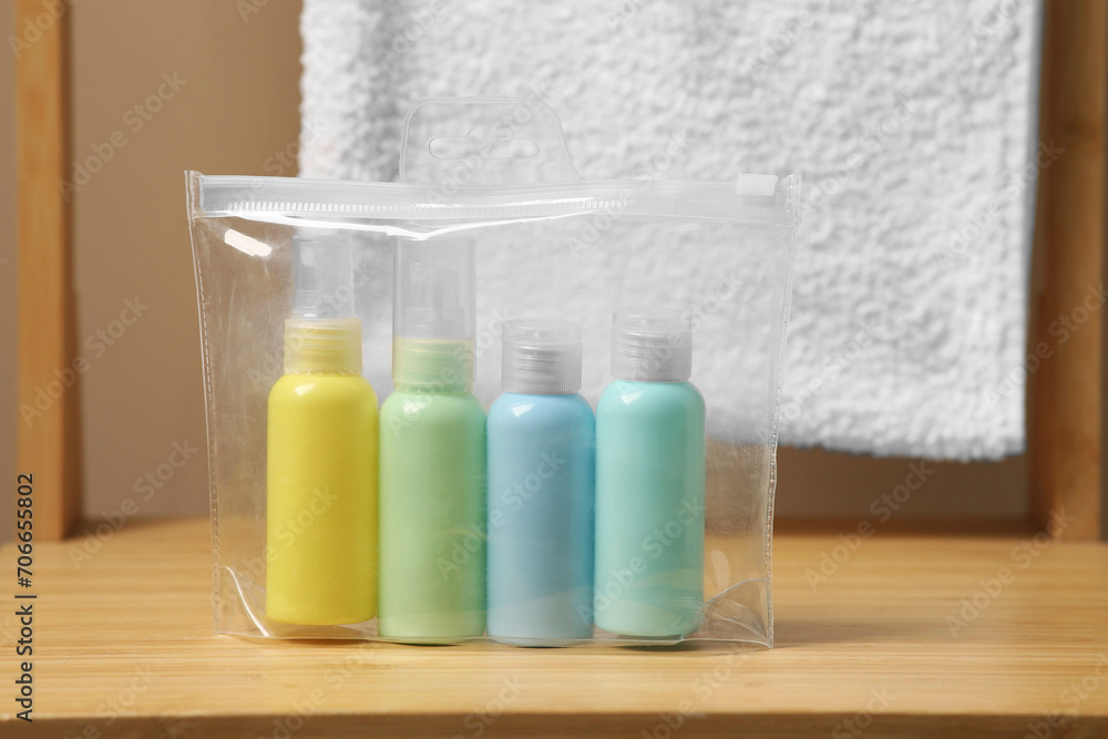 Cosmetic travel kit in plastic bag on wooden table. Bath accessories Cosmetic travel kit in plastic bag on wooden table. Bath accessories
