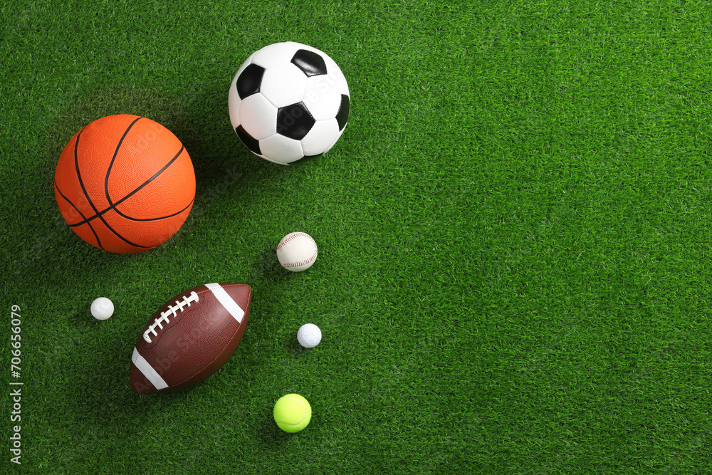 Many different sports balls on green grass, flat lay. Space for text