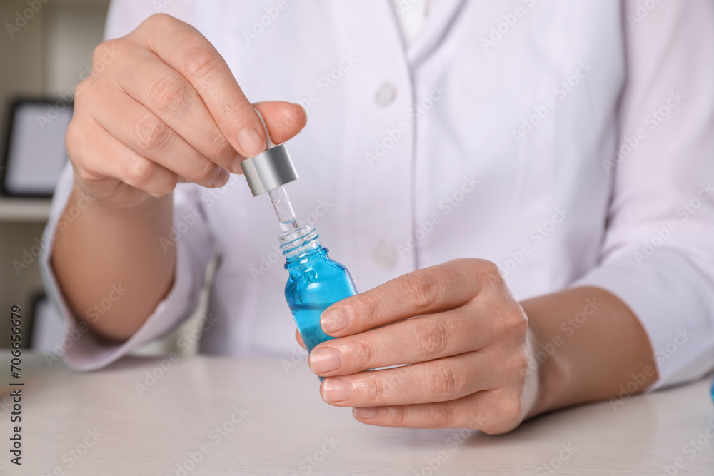 Dermatologist developing cosmetic product at white table indoors, closeup Dermatologist developing cosmetic product at white table indoors, closeup