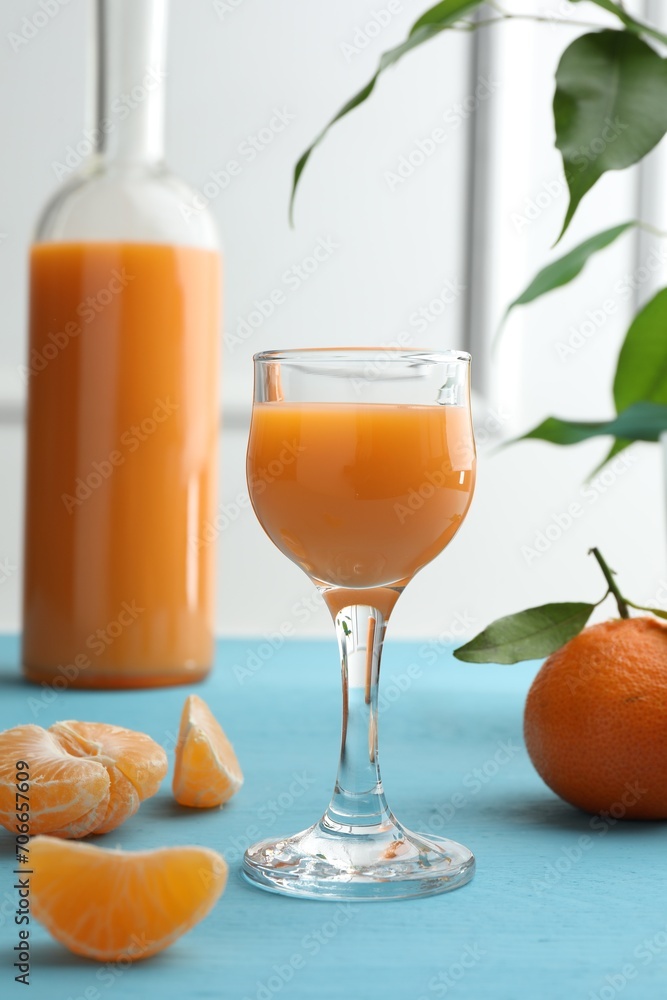 Delicious tangerine liqueur and fresh fruits on light blue wooden table Delicious tangerine liqueur and fresh fruits on light blue wooden table