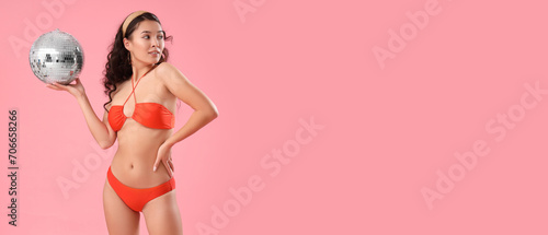 Sexy young woman in swimsuit and with disco ball on pink background with space for text © Pixel-Shot