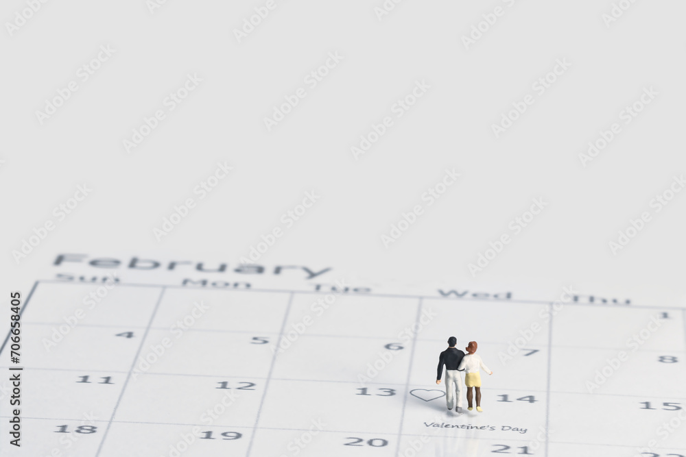 Junges verliebtes Paar steht bei der Nummer 14 auf einem Kalender im Monat Februar wegen Valentinstag , Miniaturfiguren szene Junges verliebtes Paar steht bei der Nummer 14 auf einem Kalender im Monat Februar wegen Valentinstag , Miniaturfiguren szene