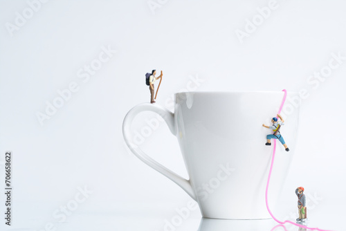 climbers climb a white coffee cup with rope, miniature figures scene,
​