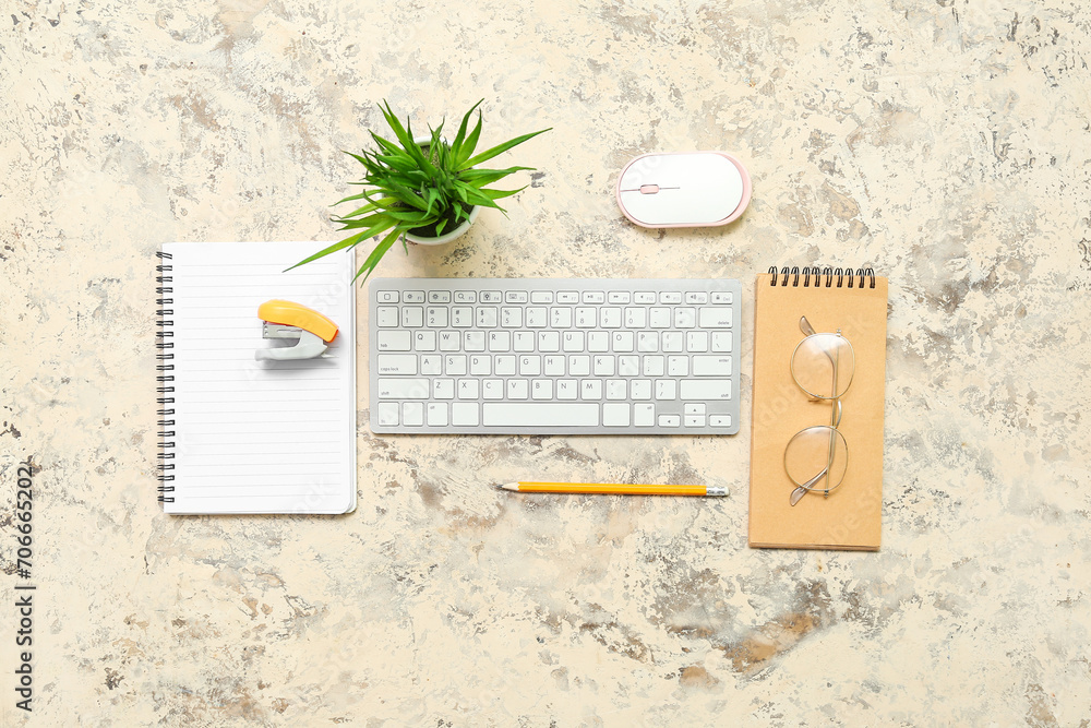 Composition with keyboard, plant, eyeglasses and notepad on grunge background