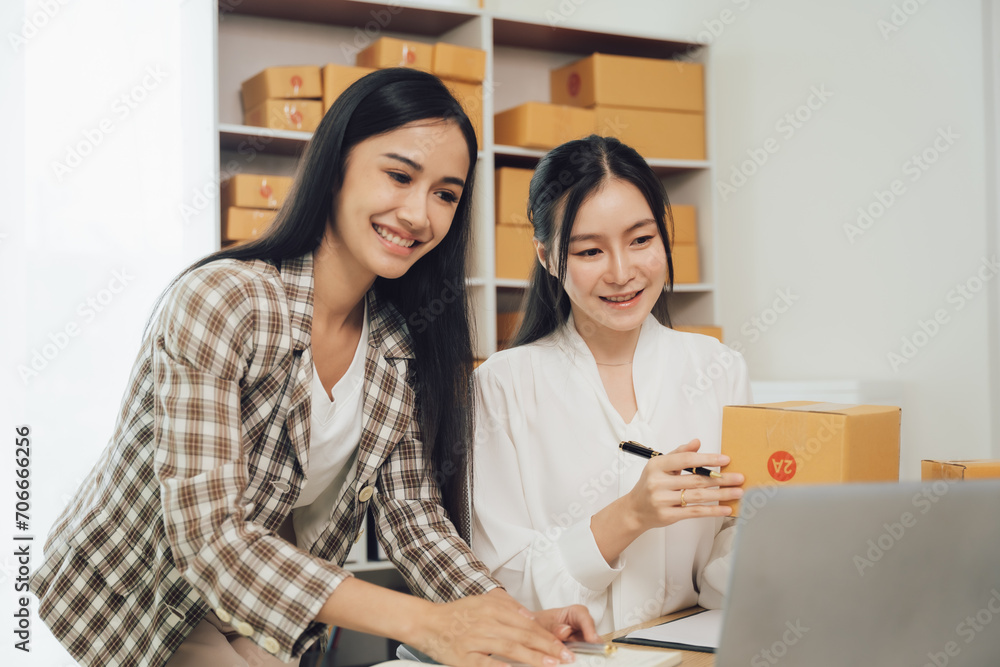 Two asian women with startup small business entrepreneur freelance working at home. checking product order. Online woman sellers working for e- Two asian women with startup small business entrepreneur freelance working at home. checking product order. Online woman sellers working for e-