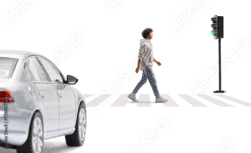 Full length portrait of a tall guy crossing a street at a pedestrian crossing