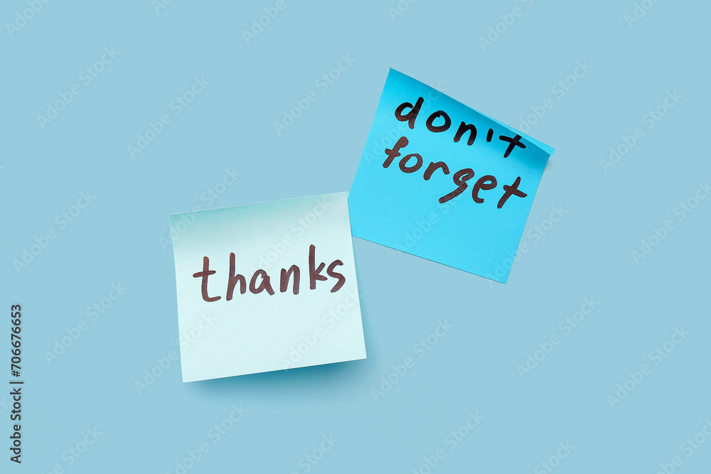 Sticky notes with word THANKS and text DON'T FORGET on blue background Sticky notes with word THANKS and text DON'T FORGET on blue background