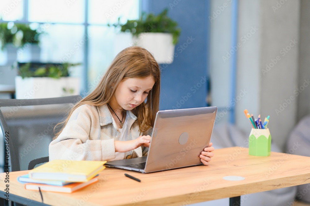 Smiling little Caucasian girl have video call distant class with teacher Smiling little Caucasian girl have video call distant class with teacher