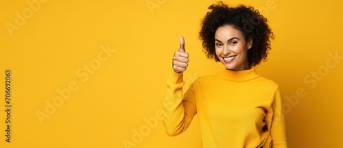 diverse mixed race woman showing thumbs up gesture on yellow background advertising banner copy space left