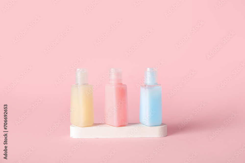 Plaster podium with bottles of cosmetic products on pink background Plaster podium with bottles of cosmetic products on pink background