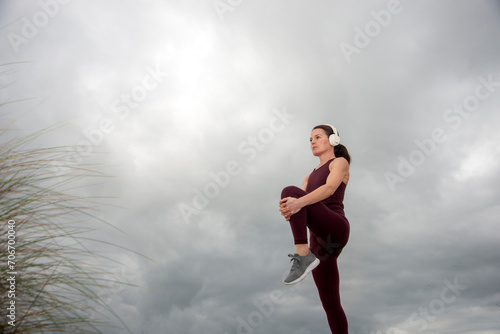 Sporty woman doing leg stretching exercises, outside