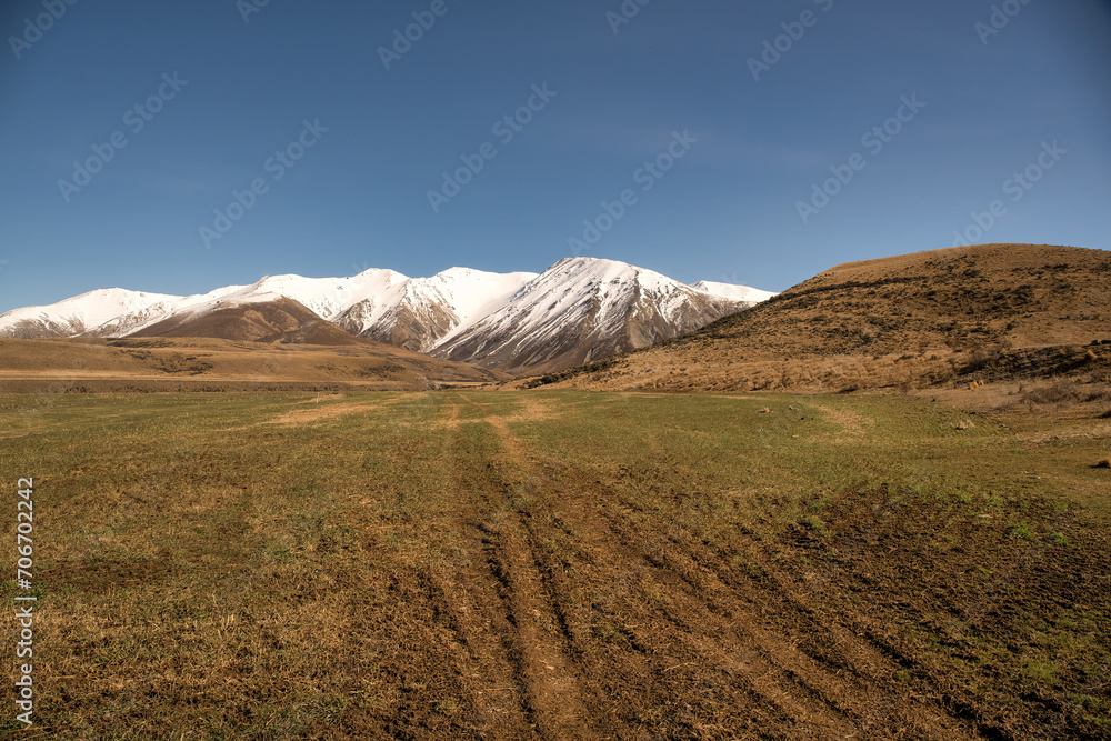 Lush farm land below the slopes of the snow capped southern alps