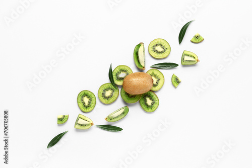 Slices of fresh kiwi and leaves on white background