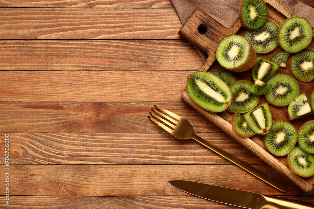 Board with slices of fresh kiwi on wooden background Board with slices of fresh kiwi on wooden background