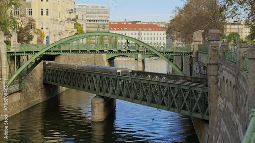 Historic Zollamtssteg Bridge across the river with subway train traveling underneath, Vienna, Austria photo