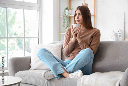 Young woman with cup of hot tea at home