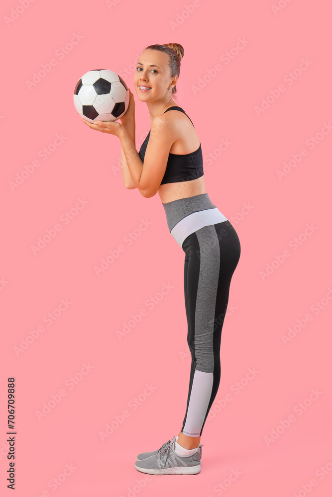 Happy beautiful young sporty woman with soccer ball on pink background Happy beautiful young sporty woman with soccer ball on pink background