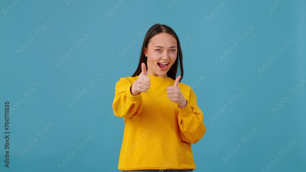Excited female making thumb up gesture on blue background Excited female making thumb up gesture on blue background