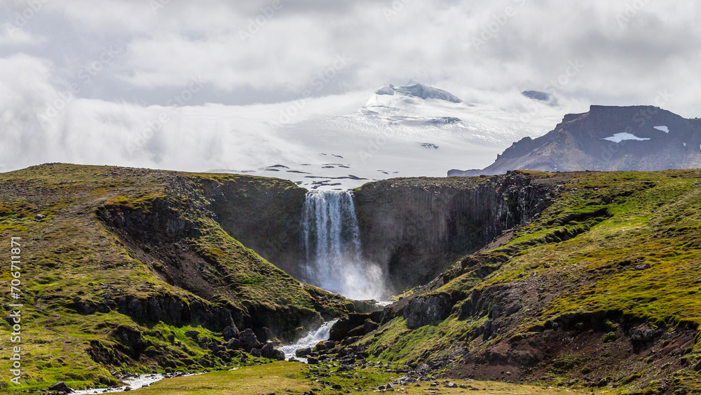Majestic Svoedufoss waterfall in front of the Snaefellsjoekull glacier in Iceland