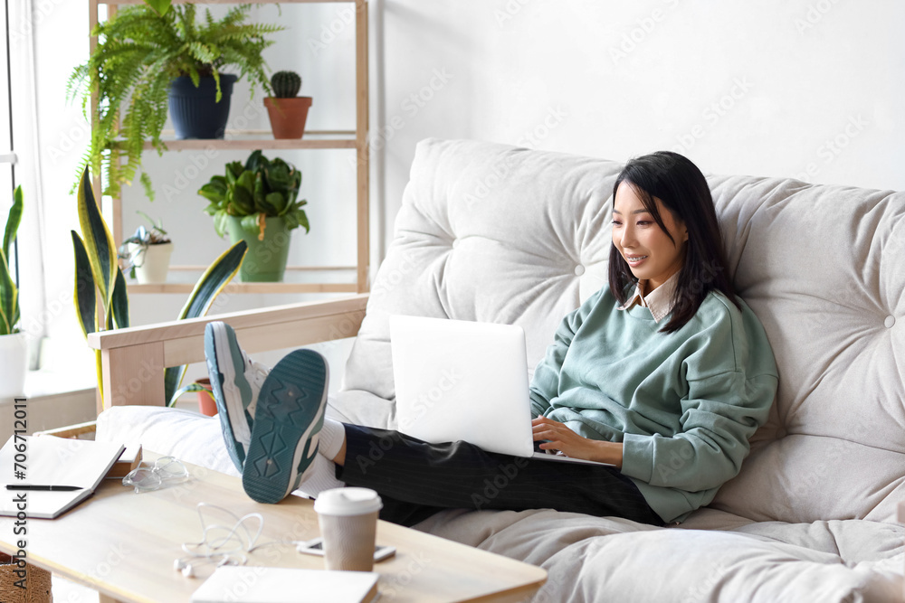Young Asian woman working with laptop at home