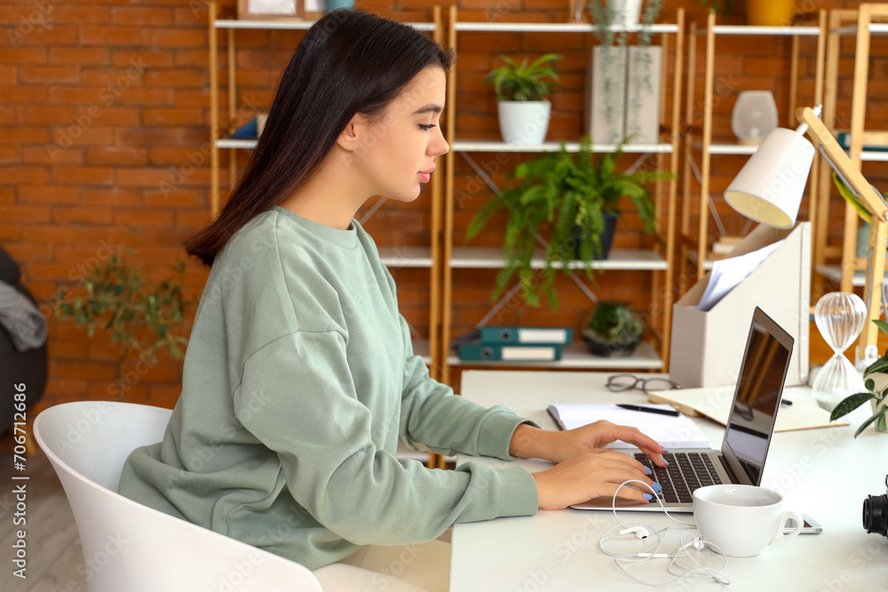 Young woman working with laptop at home office Young woman working with laptop at home office