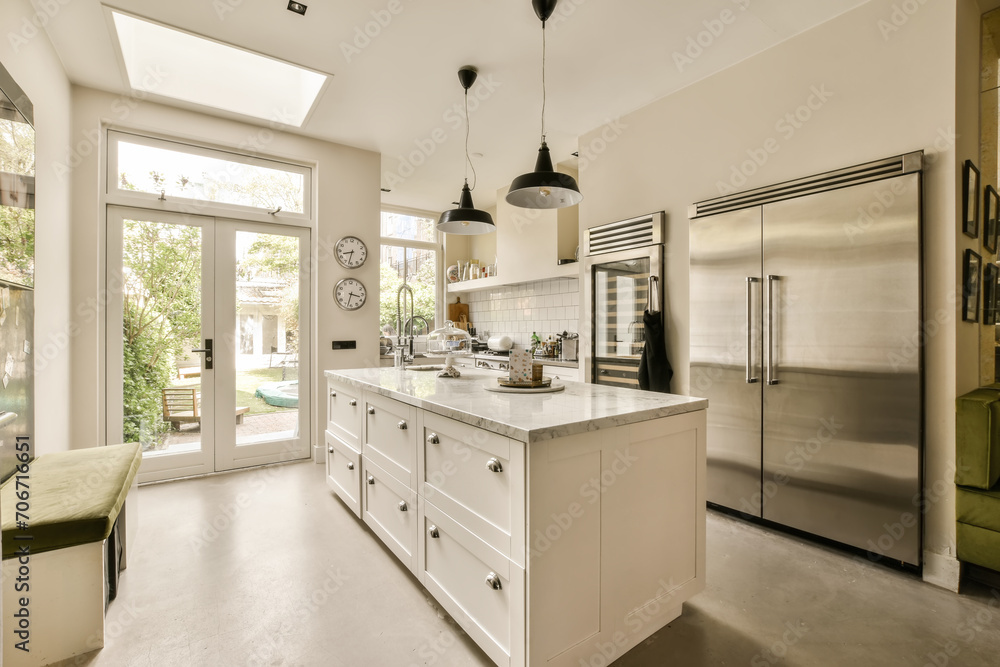 the kitchen has a large island and stainless steel refrigerator the kitchen has a large island and stainless steel refrigerator