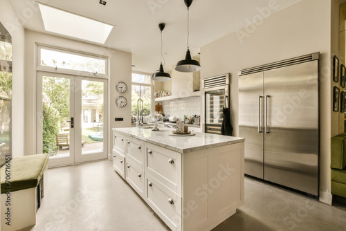 the kitchen has a large island and stainless steel refrigerator photo