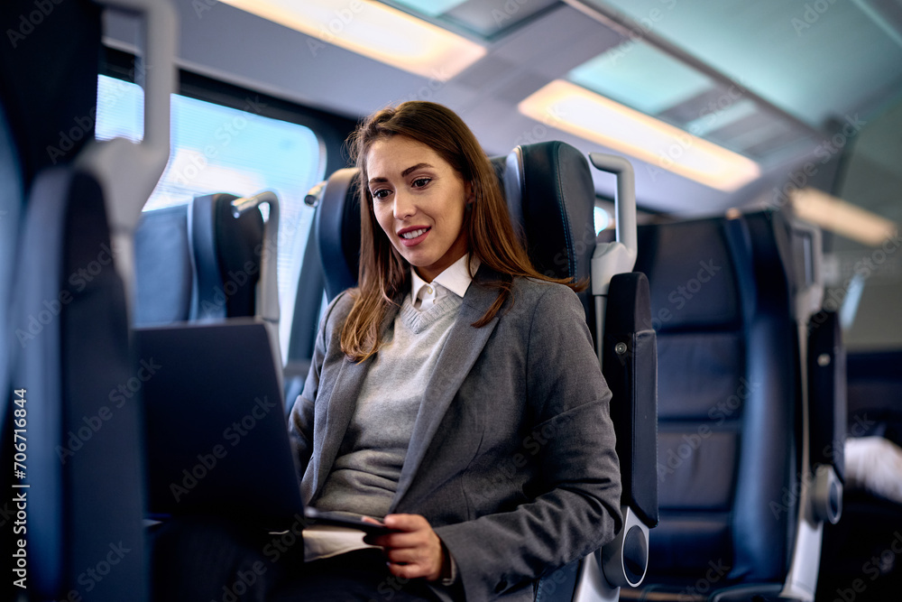 Young woman surfing the net on laptop while commuting by train. Young woman surfing the net on laptop while commuting by train.