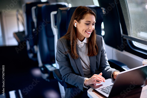 Young happy entrepreneur using her laptop while riding in train. © Drazen