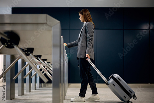 Young businesswoman passing through gate at train station. photo