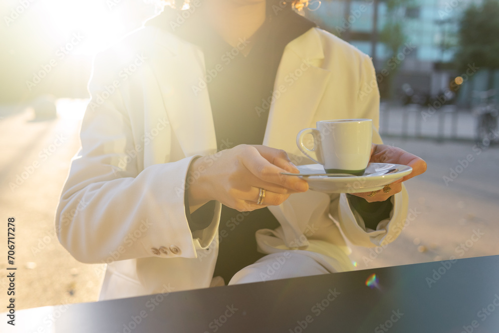 Elegant person enjoying a coffee in golden hour light Elegant person enjoying a coffee in golden hour light