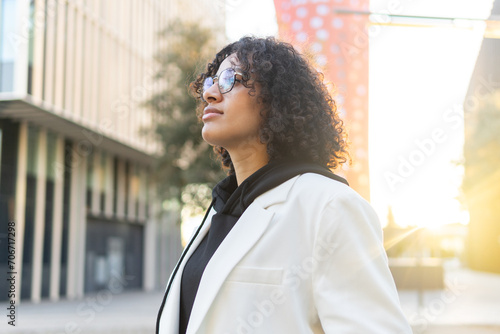 Confident young woman standing in city sunshine photo