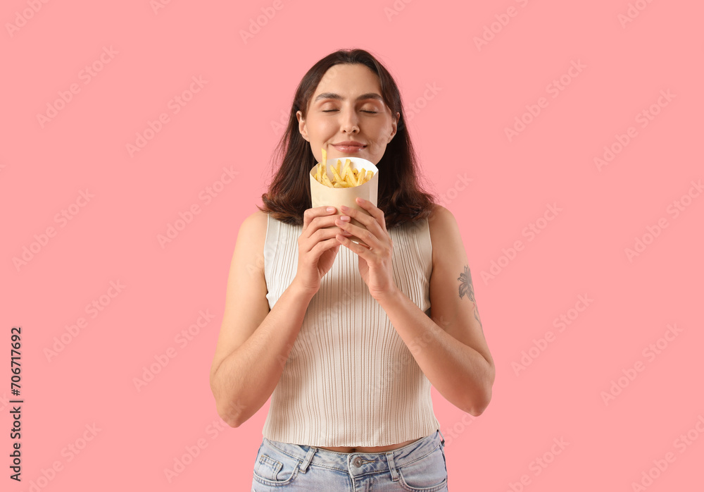Beautiful young woman with french fries on pink background Beautiful young woman with french fries on pink background