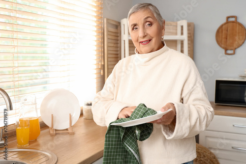 Senior woman wiping plate i...